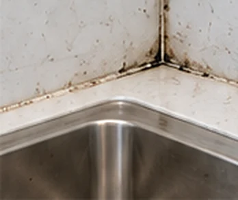 Before: mouldy, stained silicone around a kitchen sink