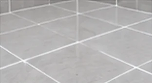 Freshly regrouted grey floor tiles with clean epoxy grout lines